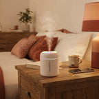 A compact mini humidifier emitting mist on a wooden nightstand with terracotta decor in a cozy bedroom.